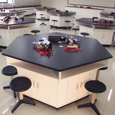 a room filled with lots of desks covered in black and white counter top tops