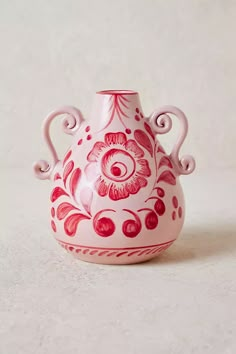 a red and white vase sitting on top of a table