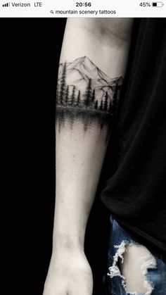 a person with a forest tattoo on their arm