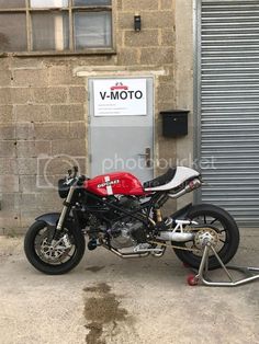 a red and white motorcycle parked in front of a building