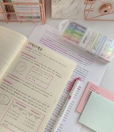 an open notebook sitting on top of a table next to some pens and other items