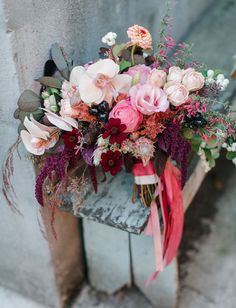 a bouquet of flowers sitting on top of a wooden bench