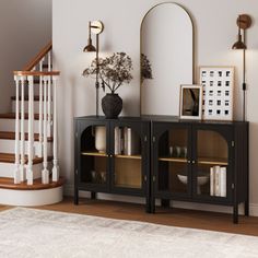 a living room with a book shelf and mirror next to a stair case in the corner