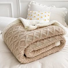 two blankets are folded on top of each other in the middle of a white bed