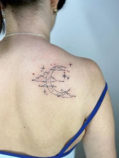 the back of a woman's shoulder with stars and a crescent tattoo on it