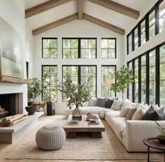 a living room filled with furniture and large windows