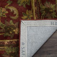 an area rug with the word faith written on it next to a wooden floor and wall