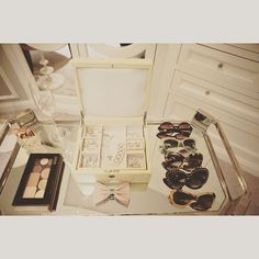 an open white box containing various items on a glass table with silverware and wine glasses