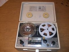 an old fashioned movie projector sitting on top of a wooden table