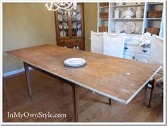 a wooden table with a white plate on it in a room filled with other furniture