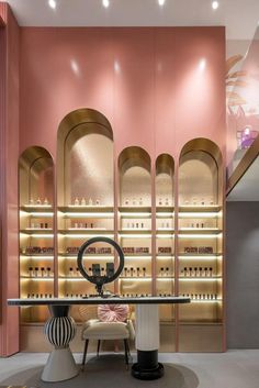 the interior of a store with pink walls and shelves filled with bottles on each shelf