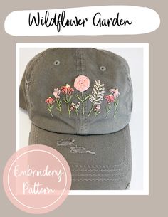 a gray hat with embroidered flowers on it and the words wildflower garden written in white