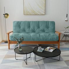 a living room with a blue futon couch and coffee table in front of it