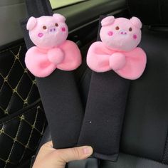 two pink teddy bears sitting in the back seat of a car