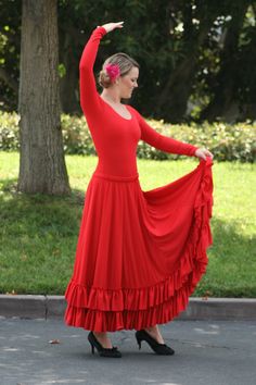 a woman in a red dress is dancing