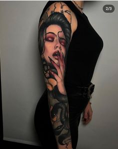 a woman with a dragon tattoo on her arm, holding her hand to her mouth