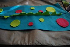 a piece of felt with green and red dots on it sitting on top of a bed