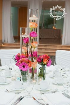 the centerpieces are filled with pink and orange flowers