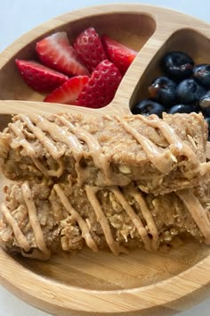 a wooden plate topped with fruit and granola