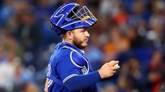 a baseball player wearing a catchers mitt on top of his head