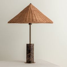 a lamp that is sitting on top of a table in front of a white wall