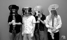 four people with guitars and helmets on their heads