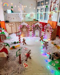 an indoor christmas scene with gingerbread houses and candy canes on the floor in front of them