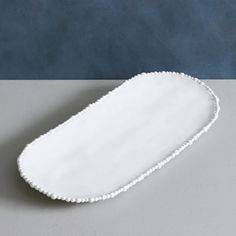 a white tray with scalloped edges on a table