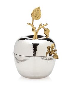 an apple shaped silver container with gold leaves on it's top and bottom, sitting in front of a white background