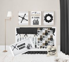 a baby crib with black and white bedding next to pictures on the wall