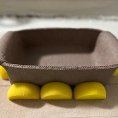 a paper mache with yellow balls in it on the floor next to some sand