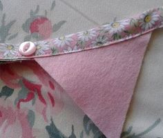 a close up of a pink flowered fabric with a small white button on it