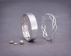 two silver rings with twisted designs on them