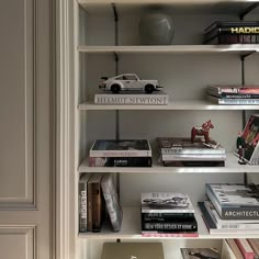 a book shelf filled with books next to a white door and lamp on top of it