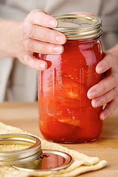 a person holding a jar filled with red liquid