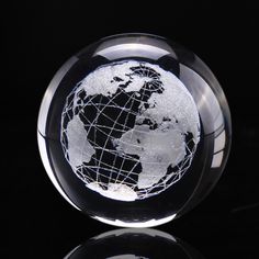 a glass globe with an image of the earth on it's surface in front of a black background