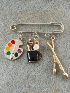 a pin with scissors, paintbrushes and other items attached to it on a carpeted surface