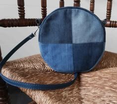 a blue purse sitting on top of a wooden chair next to a brown chair cushion