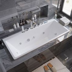 a large white bath tub sitting next to a window