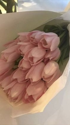 a bouquet of pink flowers in a white paper wrapper