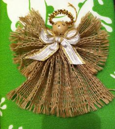 an angel ornament on a green and white cloth with gold trimmings