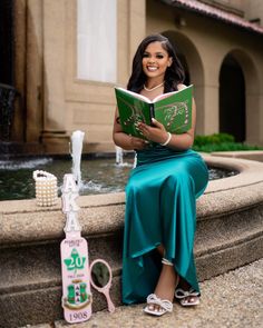 a woman sitting on a fountain reading a book