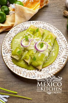 mexican food with guacamole and onions on a plate next to green peppers