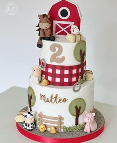 a three tiered cake with farm animals on the top and number two on the bottom