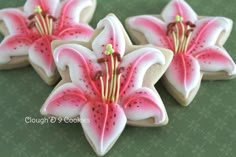 three decorated cookies with pink flowers on them