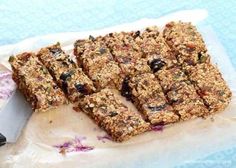 some granola bars sitting on top of a piece of paper next to a knife