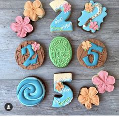 decorated cookies arranged in the shape of numbers and flowers on a wooden table with blue icing