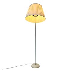 a floor lamp with a white shade on it