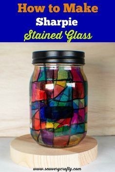 a jar filled with stained glass sitting on top of a wooden board