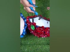 someone is decorating something on the grass with plastic cups and scissors to make it look like they're dancing